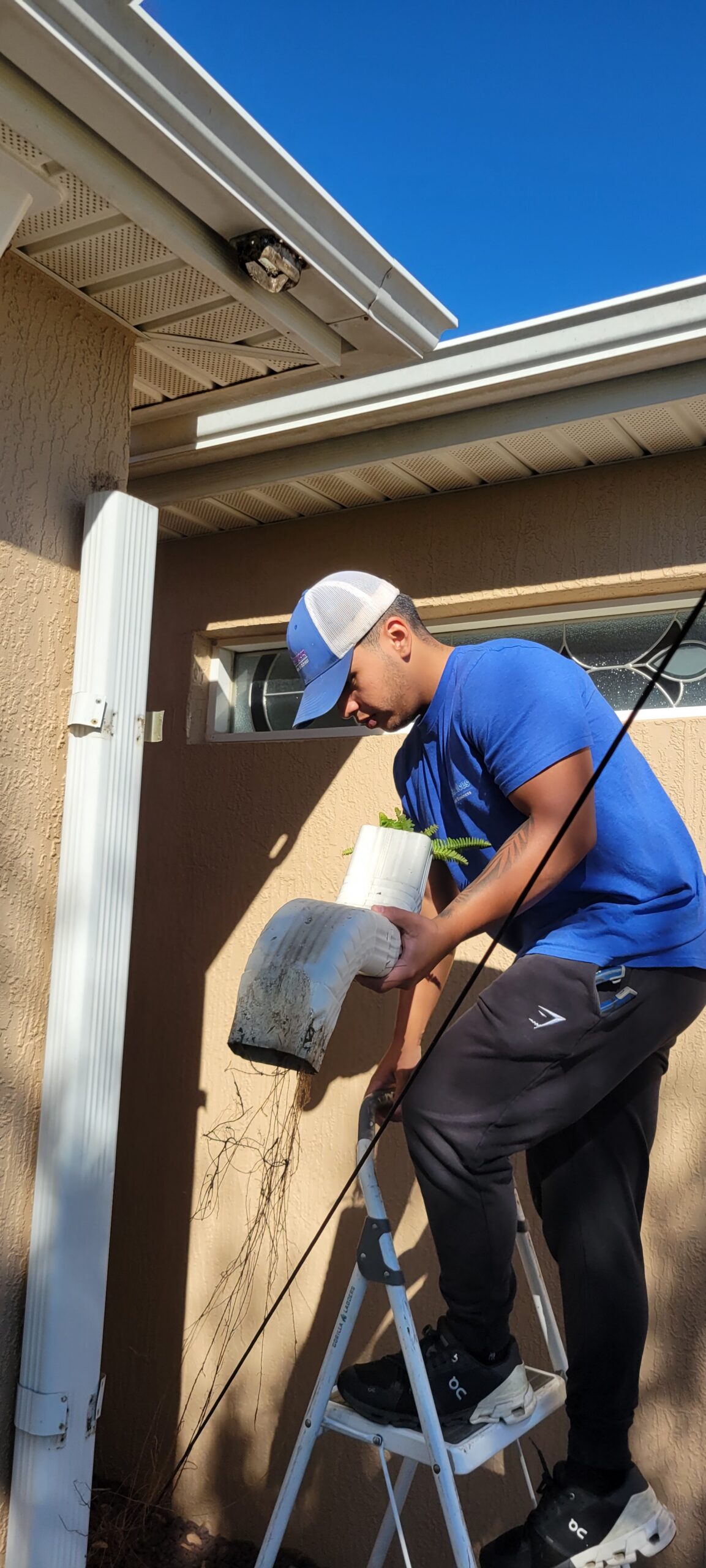 Technician removing debris during residential gutter cleaning in The Villages, Florida