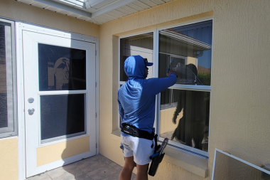 Professional window cleaner washing large residential windows in The Villages, Florida
