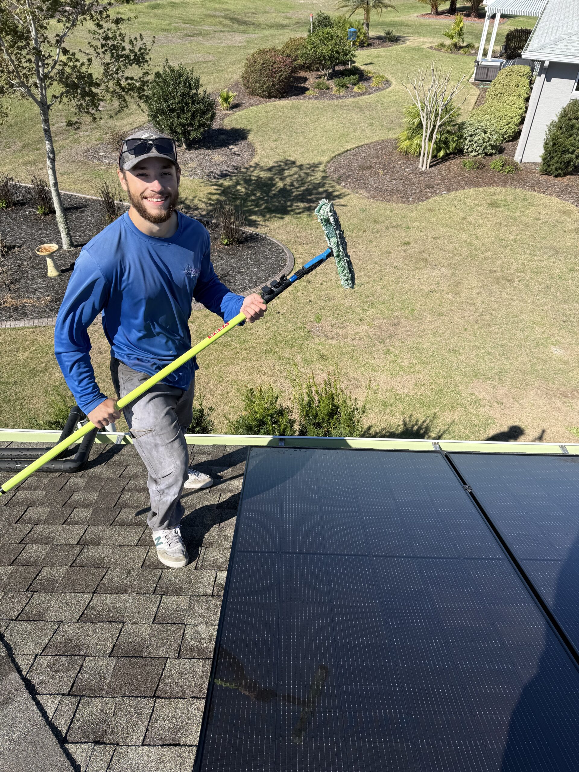 Residential solar panel cleaning technician working on rooftop