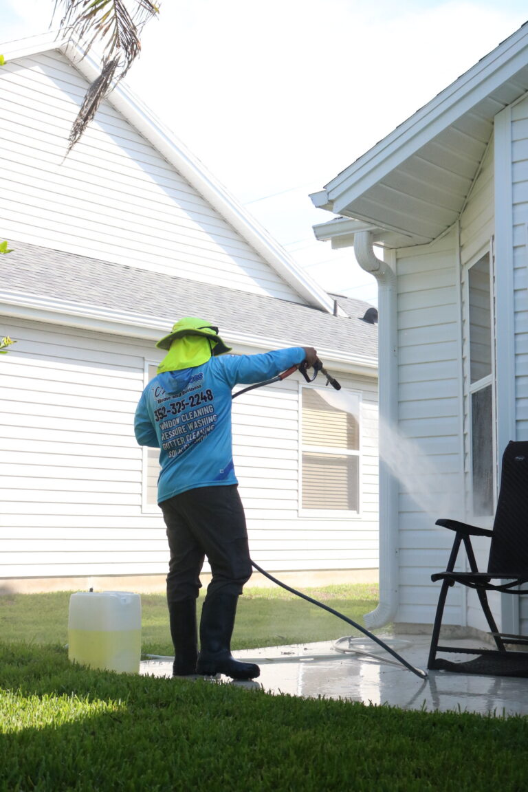 C2 Services technician soft washing white vinyl siding on a Florida home